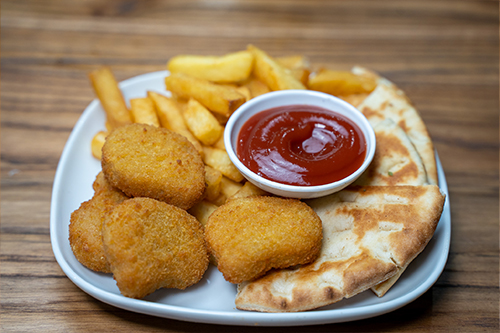 Kids meal including chicken nuggets, chips, pita bread and sauce on a plate
